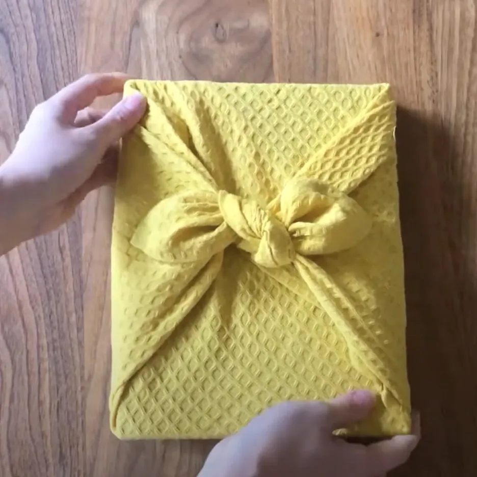Подарок упакованный в желтое полотенце