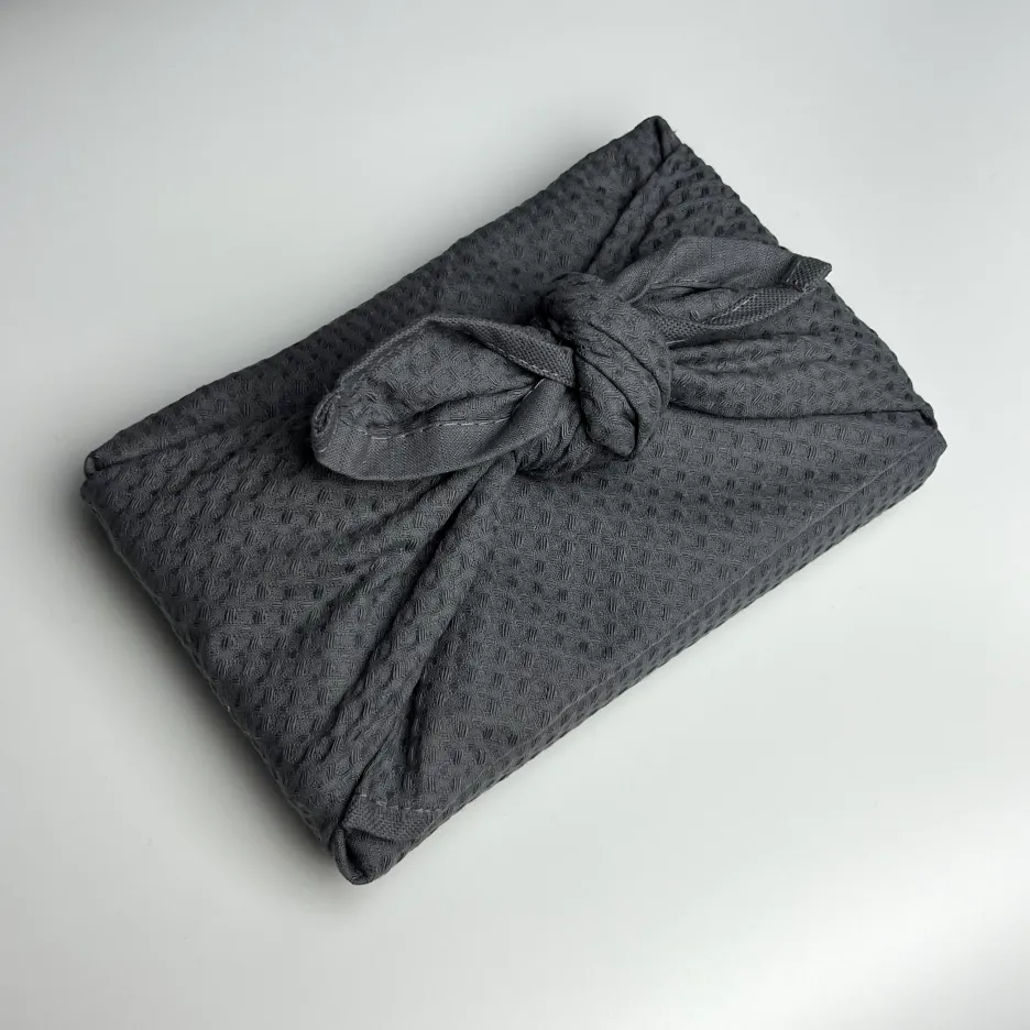 Подарок упакованный в черное полотенце